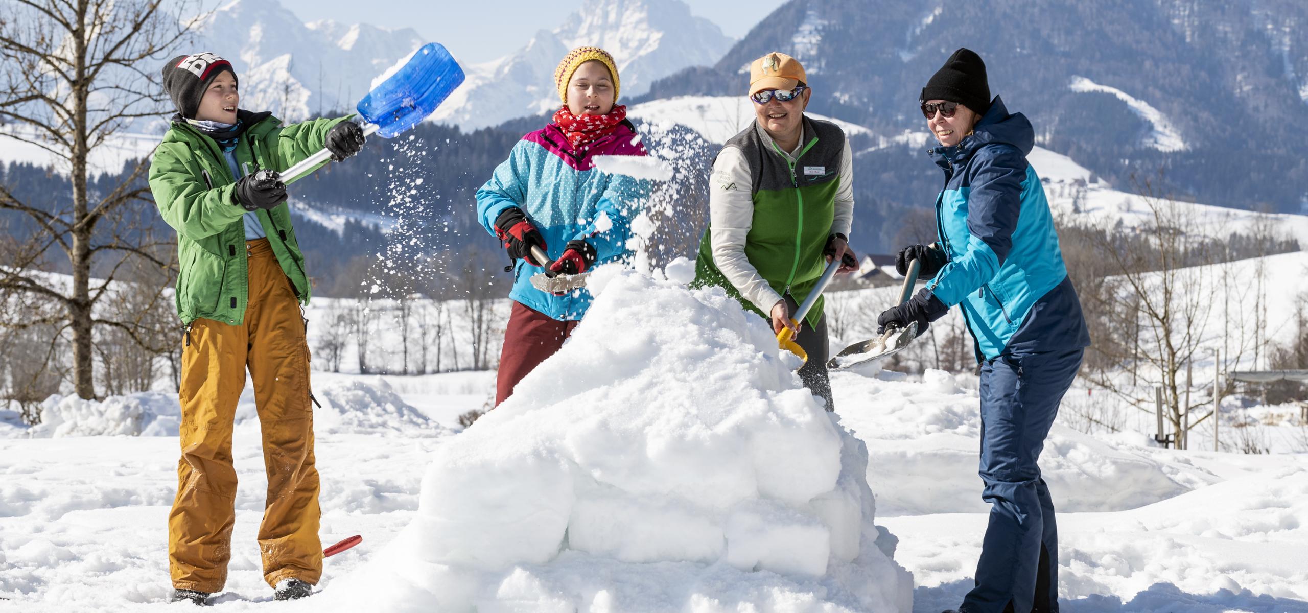 Nationalpark Rangerin baut mit einer Familie einen Iglu aus Schnee