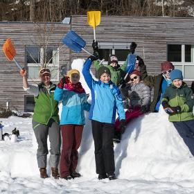 Rangerin und eine Gruppe Kinder bauen eine Schneeskulptur