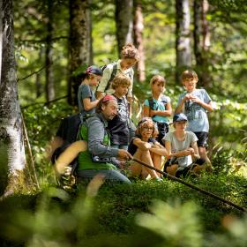 Nationalpark Rangerin und Ranger mit einer Gruppe Schulkinder im Wald