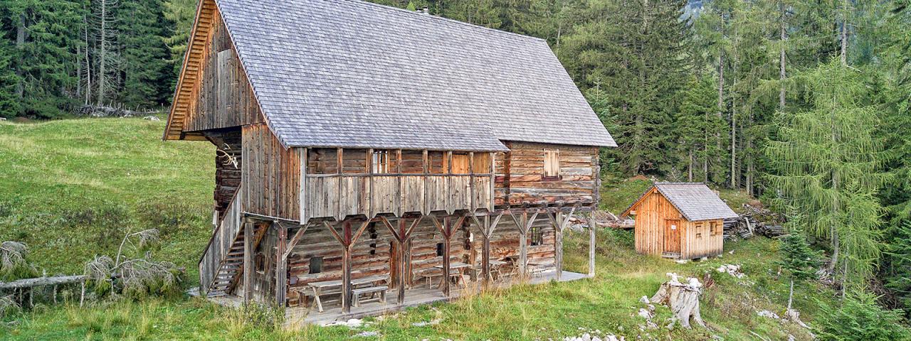 Das zweistöckige Holzgebäude der Bärenriedlauhütte steht auf einer Waldlichtung im Sengsengebirge