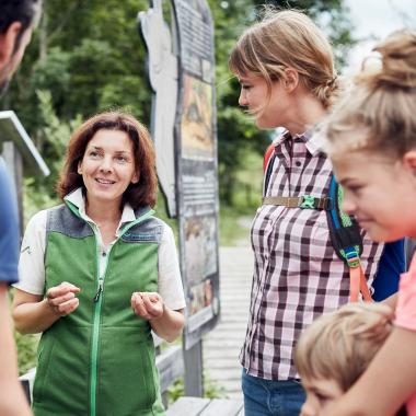 Nationalpark Rangerin spricht mit Familie mit Kindern