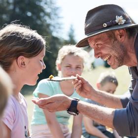 Nationalpark Ranger reicht einem Mädchen Essen auf einem Holzlöffel